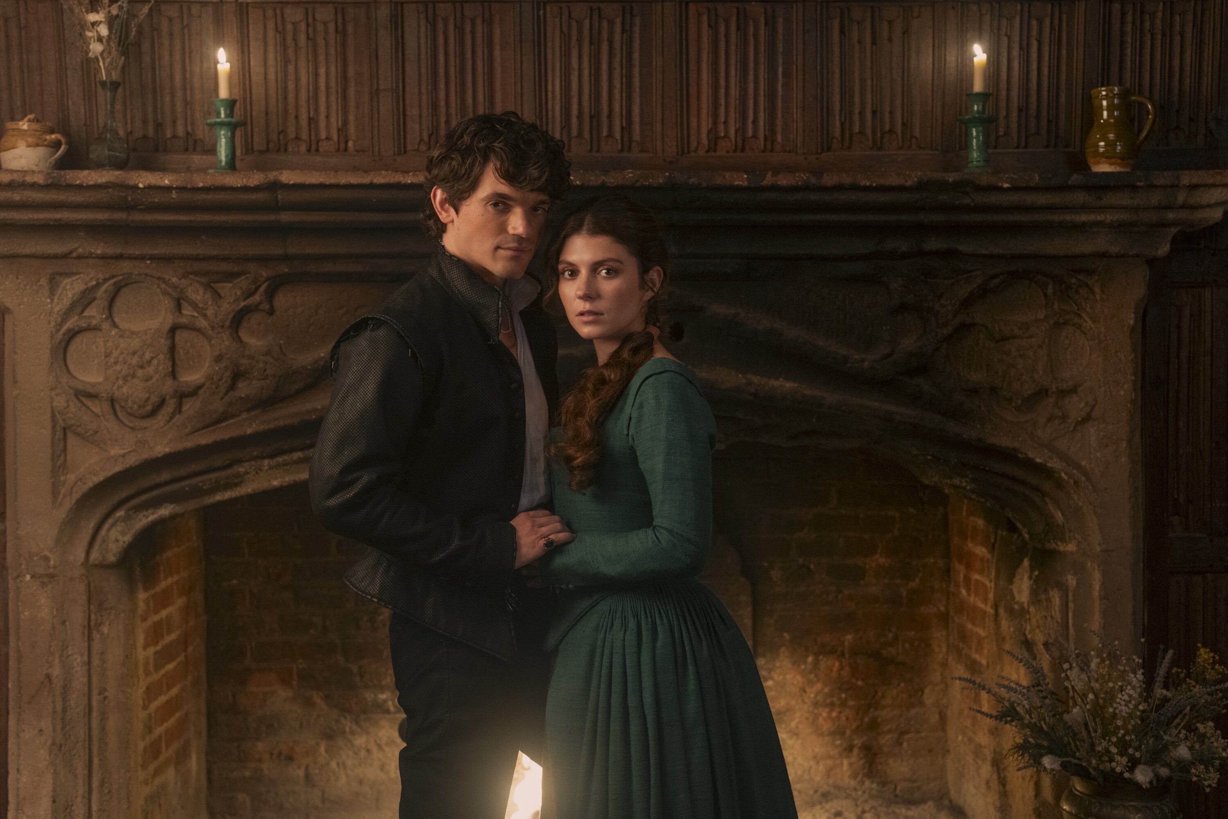 Edward Bluemel and Emily Bader in My Lady Jane standing in front of a fireplace