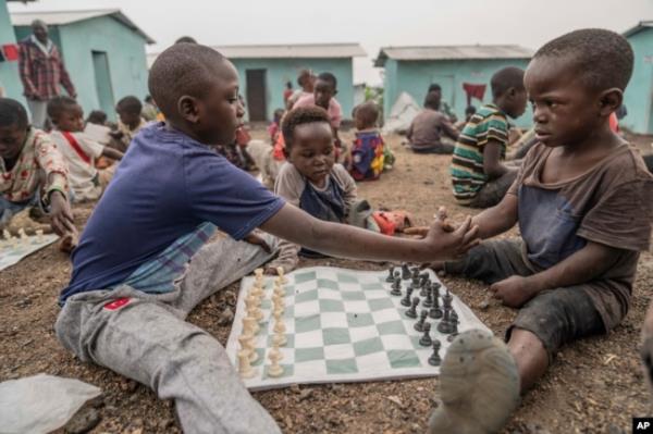 Children shake hands before they play a chess game at the Soga Chess Club of the internally displaced persons camp in Kanyaruchinya, Democratic Republic of Congo, on July 29, 2024.